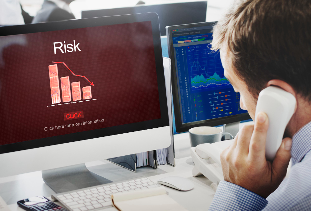 A man talking on phone while looking at chart that shows risk chart.