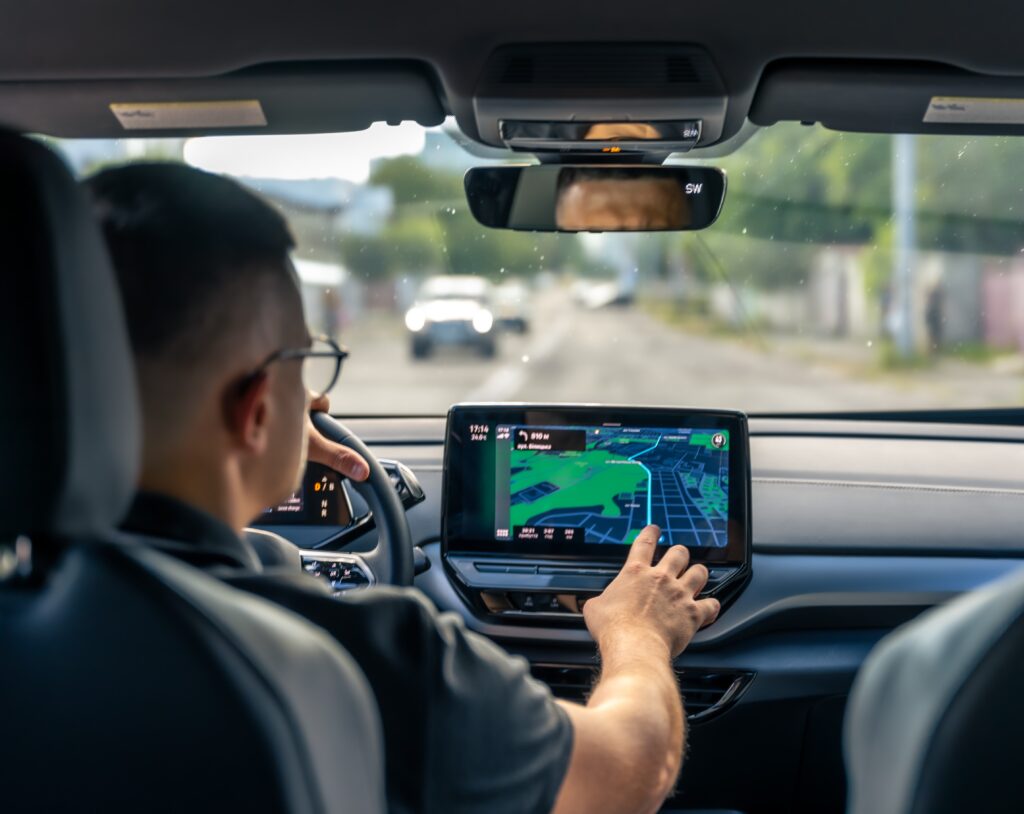 Man touching screen of a GPS navigation system in his car.