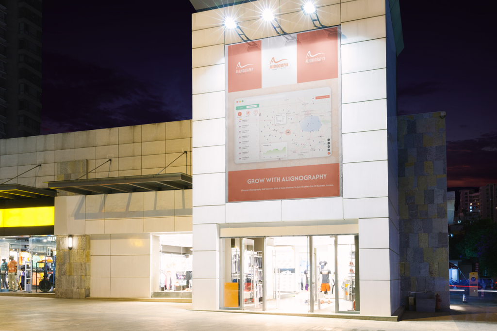 Luminous Storefront at night with a huge banner of alignography app shown.